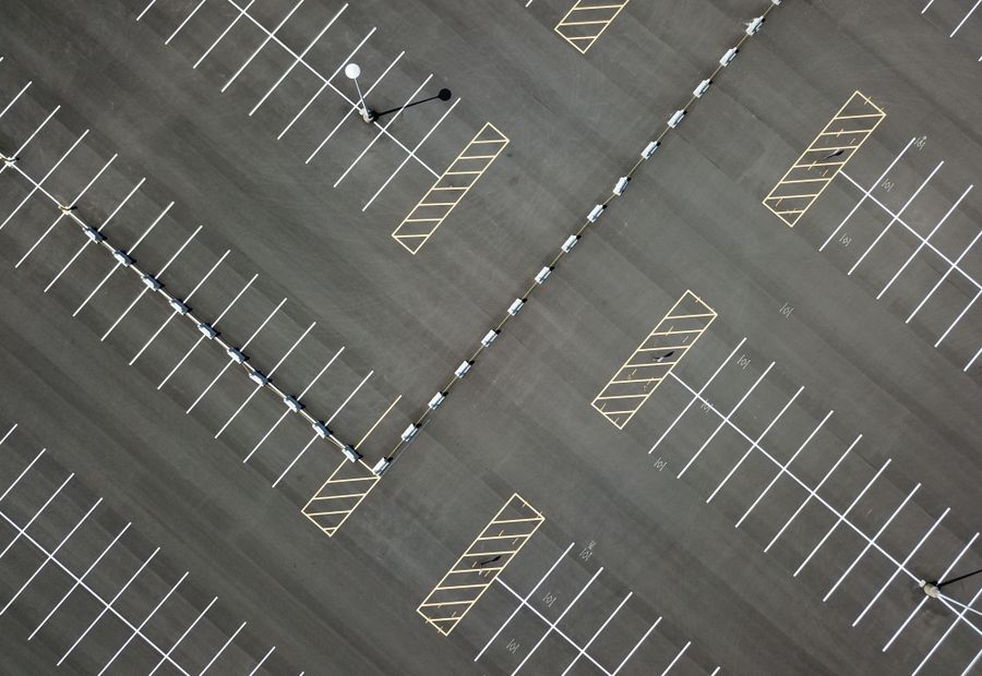 Overhead view of a freshly paved commercial lot with new white stall striping